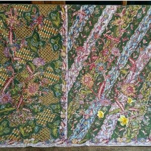 May include: A green fabric with a floral pattern in shades of pink, yellow, blue, and red. The fabric has a woven texture and a subtle sheen.