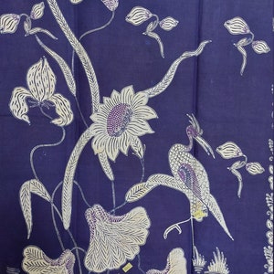 Peut inclure: Textile bleu marine avec un motif floral et aviaire. Le motif présente des fleurs blanches, des feuilles et un oiseau avec des accents violets. Le textile a un motif répétitif sur les bords.