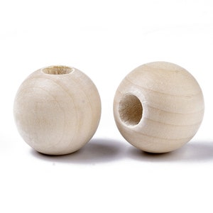 May include: Two unfinished wooden spherical beads with large, centered holes. The beads are a light, natural wood color, showing the wood grain. These beads are suitable for crafting and jewelry making.