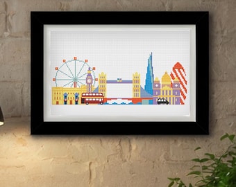 May include: A framed cross-stitch artwork depicting a colorful pixelated London skyline. The design features the London Eye, Big Ben, Tower Bridge, a red double-decker bus, and other iconic city landmarks rendered in vibrant, multi-colored thread.