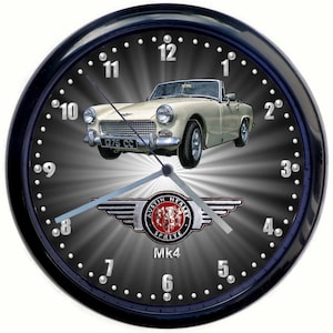Può includere: Un orologio da parete nero con un'auto Austin Healey Sprite Mk4 bianca sul quadrante. L'orologio ha un quadrante argentato con numeri neri e uno sfondo argentato con un motivo radiale. L'auto è una decappottabile con una carrozzeria bianca e un interno nero. L'orologio ha una cornice argentata con punti neri attorno al bordo.