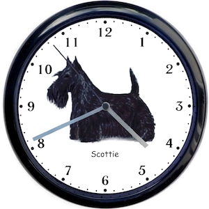 May include: Black and white clock with a black Scottie dog illustration on a white background. The clock face has black numbers and hands. The clock has a black frame.
