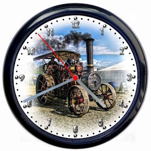 May include: A black wall clock with a white face and black numbers. The clock face features a vintage steam engine with black smoke billowing from the chimney. The engine is red and has a large silver wheel.