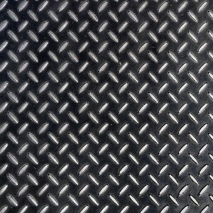 May include: Black metal sheet with a diamond pattern. The surface is textured and has a slightly worn look.