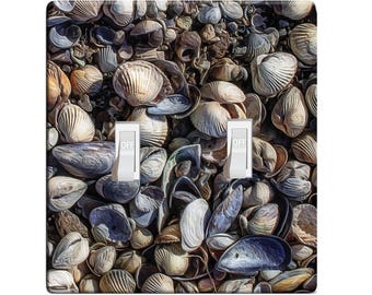 May include: A light switch cover with a close-up image of a variety of seashells in shades of brown, gray, and white. The switch cover has two toggle switches labeled "OFF".
