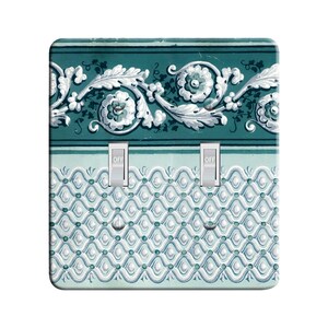 May include: A light switch cover with a teal and white floral pattern. The cover has three toggle switches labeled "OFF".