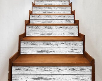 May include: Wooden staircase with white and gray plank-style stair treads. The risers are a warm brown, and the steps have a distressed, weathered appearance. The design creates a rustic, farmhouse aesthetic.