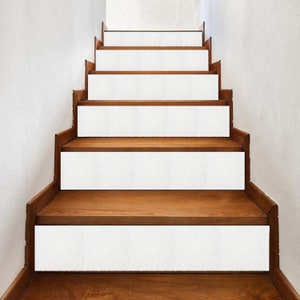 May include: White non-slip stair treads on wooden stairs. The treads are designed to prevent slipping and add a decorative touch to the stairs.