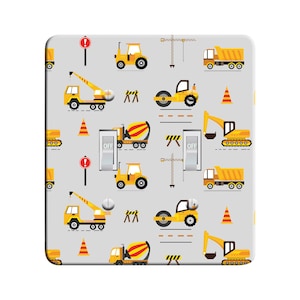 May include: A light gray light switch cover with a repeating pattern of yellow construction vehicles, including a crane, dump truck, cement mixer, bulldozer, and road roller. The switch cover has two toggle switches labeled "OFF".