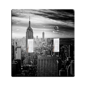 May include: Black and white photograph of the New York City skyline featuring the Empire State Building. The image is designed for a light switch cover.