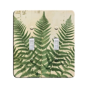 May include: A light switch plate with a vintage-style fern pattern. The plate has two toggle switches with the word "OFF" printed on them.