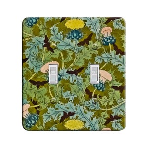 May include: A light switch cover with a floral pattern featuring green leaves, yellow flowers, and blue butterflies. The switch cover has two toggle switches labeled "OFF".