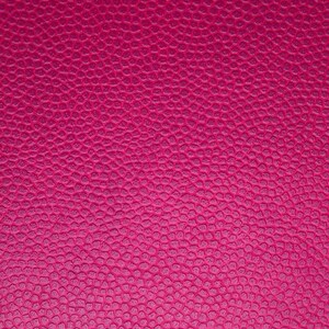 May include: A close-up of a textured, pink surface. The surface has a subtle, pebbled texture.