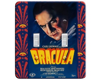 May include: A vintage movie poster for the film Dracula, featuring Bela Lugosi as Dracula. The poster is on a blue background with red and white accents. The text on the poster reads "Carl Laemmle presents Dracula featuring Bela Lugosi, David Manners, Helen Chandler, Dwight Frye, Edward Van Sloan, A Tod Browning Production, A Universal Picture."