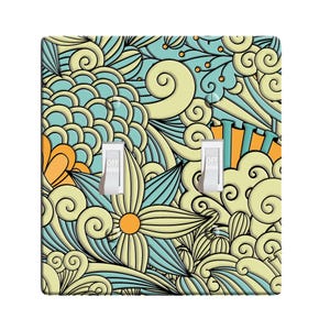 May include: A light switch cover with a whimsical design featuring a yellow, blue, and orange floral pattern. The cover has two toggle switches labeled "OFF".