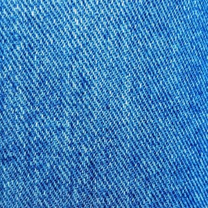 May include: Close-up of a blue denim fabric with a diagonal weave pattern.