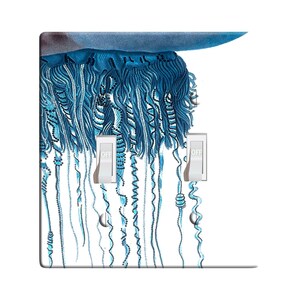Puede incluir: Una placa de interruptor de luz azul claro y blanco con una imagen de primer plano de una medusa portuguesa azul con largos tentáculos. La placa del interruptor tiene dos interruptores de palanca etiquetados como "OFF".