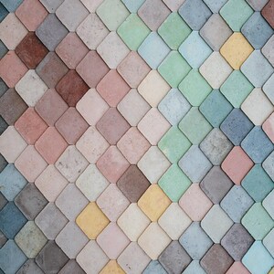 May include: A wall covered in a mosaic of small, colorful, diamond-shaped tiles. The tiles are arranged in a diagonal pattern, creating a visually interesting texture. The colors range from light blue to pink, green, and yellow.