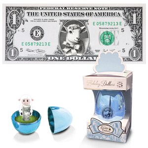 A nota oficial de dólar do cordeiro da Páscoa com ovo metálico azul e caixa de presente. 1,0 dólar real. Bancável e gastável. Recheio / Enchimento de Cesta de Páscoa.