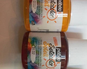 Op de afbeelding: Vier flessen Pebeo Setacolor Soleil textielverf. De flessen zijn gelabeld met de kleuren: Vermiljoen, Boterbloem, Pruim en Lichtgroen. Elke fles is 110 ml.