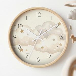 May include: A round wall clock with a light wood frame. The clock face features a cream background with watercolor clouds and gold stars. Black numerals mark the hours, and the hands are white.
