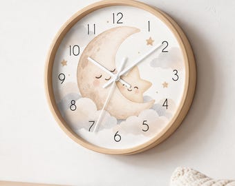 May include: A round wall clock with a light wood frame and a white face. The clock features a whimsical illustration of a smiling crescent moon and a small star nestled among soft clouds. Black numerals mark the hours, and white hands indicate time.