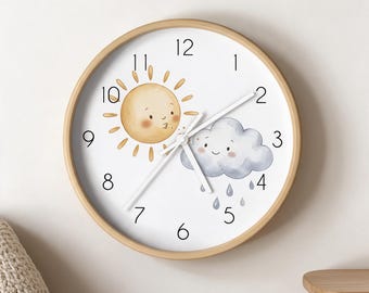 May include: A round wall clock with a light wood frame and a white face. The dial features black numerals and a whimsical illustration of a smiling sun and a rain cloud with droplets. Three thin white hands indicate the time on the clock face.