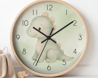 May include: A round wall clock with a light wood frame and a pale green face featuring a watercolour illustration of a seated green dinosaur. The clock has black hour, minute, and second hands, and black numerals from one to twelve.