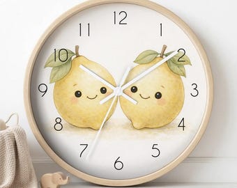 May include: A round wall clock with a light wood frame and a white face. The clock features a watercolour illustration of two smiling yellow lemons with green leaves. The numbers are black, and the clock has three white hands for timekeeping.