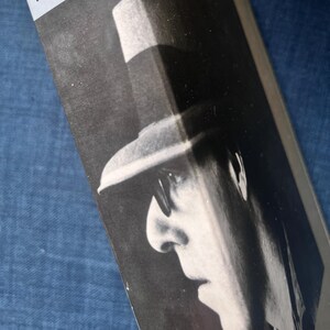 Peut inclure: Couverture de livre en noir et blanc avec le profil d'une personne portant un chapeau et des lunettes. Le nom "WOODY ALLEN" est imprimé en blanc sur une bande gris clair en haut du livre.