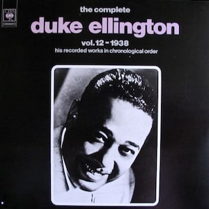 May include: A vintage vinyl record album cover for "The Complete Duke Ellington Vol. 12 - 1938." The cover is black with pink text and a black and white portrait of Duke Ellington.