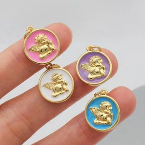 K&ouml;nnte beinhalten: Vier goldfarbene Engelscharms mit Emaille-Akzenten. Die Charms sind rund und zeigen einen Cherub mit Fl&uuml;geln. Die Emaillefarben sind rosa, lila, wei&szlig; und blau.