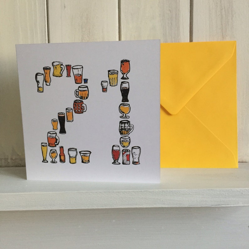 May include: A white card with a yellow envelope. The card features a design of 21 beer glasses and mugs in various shapes and sizes. The number 21 is formed by the glasses and mugs.