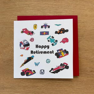 Puede incluir: Una tarjeta de felicitación blanca con borde y sobre rojos. La tarjeta presenta ilustraciones coloridas de coches de carreras, un casco y una gorra. Las palabras "Happy Retirement" están impresas en negro.