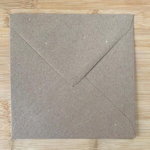 May include: A square envelope made of light brown, textured kraft paper. The envelope features a triangular flap that folds down to the center, creating a clean, simple design with visible paper fibers throughout the surface of the material.