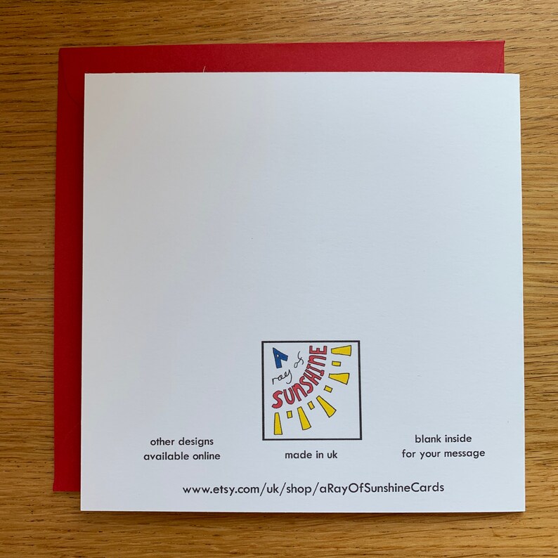 May include: A white card with a red border. The card has a yellow sun with rays and the text "A ray of sunshine" in blue and red. The text "other designs available online" is in black. The text "made in uk" is in black. The text "blank inside for your message" is in black. The text "www.etsy.com/uk/shop/aRayOfSunshineCards" is in black.