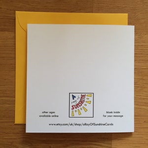 May include: A white card with a yellow envelope. The card has a logo that says "A ray of sunshine" with a sun graphic. The text "other ages available online" and "www.etsy.com/uk/shop/aRayOfSunshineCards" is printed on the card. The text "blank inside for your message" is also printed on the card.