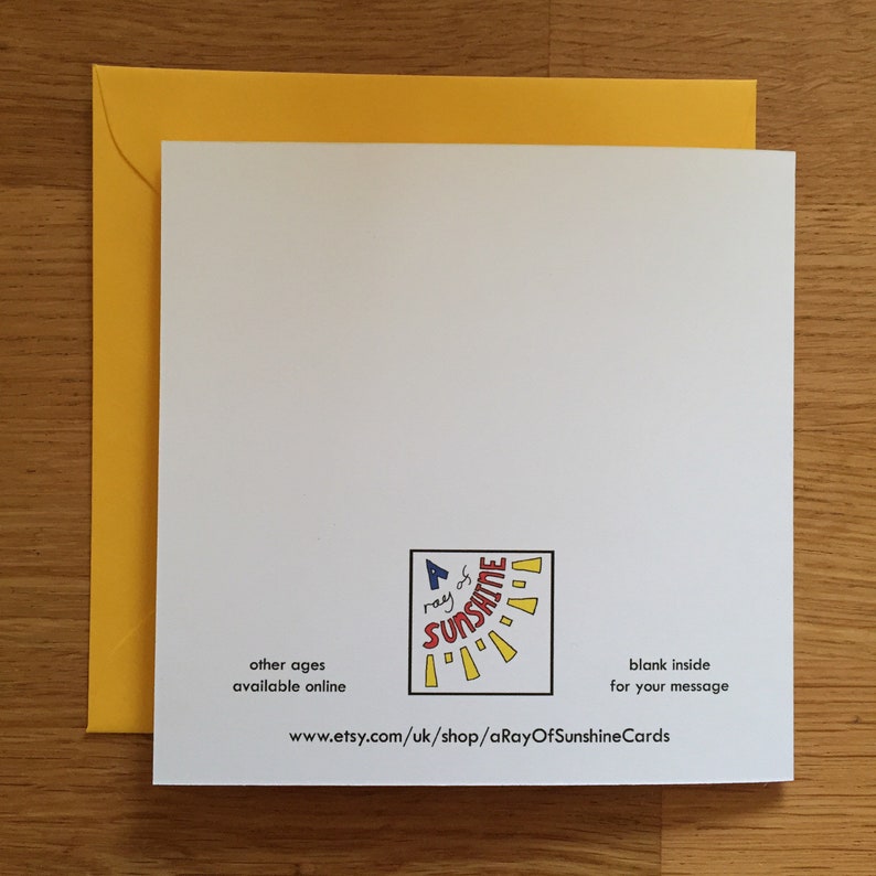 May include: A white card with a yellow envelope. The card has a logo that says "A ray of sunshine" with a sun graphic. The text "other ages available online" and "www.etsy.com/uk/shop/aRayOfSunshineCards" is printed on the card. The text "blank inside for your message" is also printed on the card.