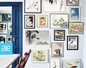 May include: A white wall with a gallery of framed artwork in various styles and colors. The artwork includes Japanese woodblock prints, traditional Asian paintings, and modern abstract art. The frames are black and white, and the artwork is arranged in a symmetrical pattern.