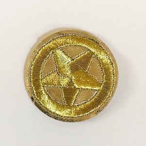 May include: A gold embroidered patch with a five-pointed star in the center.