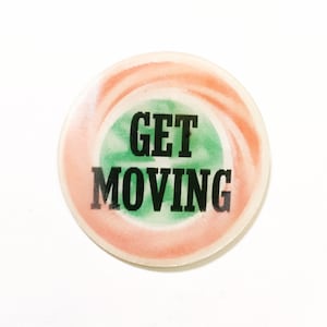 May include: A round, pink and green button with the text "GET MOVING" in black.