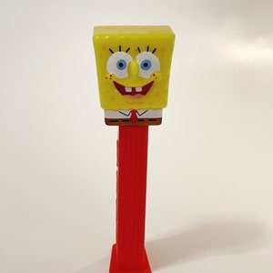 May include: A red and yellow plastic SpongeBob SquarePants character Pez dispenser.