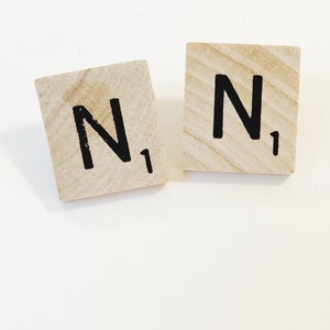 May include: Two wooden Scrabble tiles with the letter "N" and the number "1" printed on them.