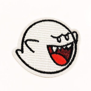 Könnte beinhalten: Weißer gestickter Aufnäher mit einem Cartoon-Geist mit weit offenem Mund und roter Zunge. Der Geist hat schwarze Augen und einen schwarzen Umriss.