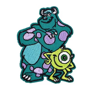 May include: Embroidered patch featuring the characters Sully and Mike from the animated movie Monsters, Inc. Sully is a large teal monster with purple spots, and Mike is a small, one-eyed green monster. The patch has a black border.