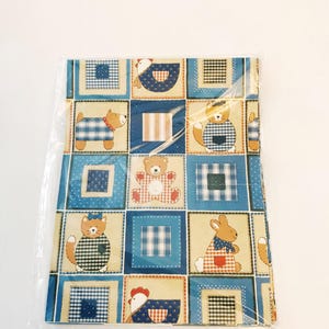 May include: A sheet of blue and yellow wrapping paper with a patchwork design featuring various animals, including a cat, dog, bear, rabbit, and chicken. The animals are all wearing clothes and have a whimsical, cartoon-like style.