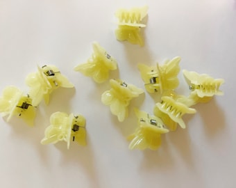 May include: A set of ten yellow butterfly hair clips. The clips are made of plastic and have a spring-loaded mechanism.