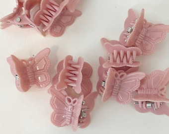 May include: A set of 10 pink butterfly hair clips. The clips are made of plastic and have a spring-loaded mechanism. They are perfect for holding back hair or adding a touch of whimsy to any hairstyle.