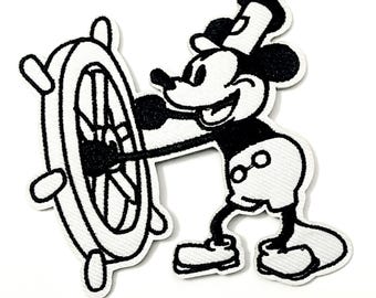 May include: Black and white embroidered patch featuring a cartoon mouse character steering a ship's wheel. The character is wearing a sailor's hat and shorts. The patch has a white border.