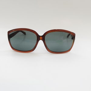 May include: Brown tortoise shell sunglasses with dark gray lenses.